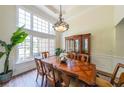 Elegant dining room featuring hardwood floors, a large window, and decorative chandelier at 6510 Newcastle Way, Cumming, GA 30040