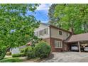 Rear exterior view of home with brick and siding, carport with 2 parked cars at 7310 Ne Wynhill Ne Dr, Atlanta, GA 30328