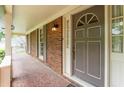 Front porch with brick flooring, columns, and a painted front door with sidelights at 7310 Ne Wynhill Ne Dr, Atlanta, GA 30328