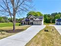 New construction home featuring a long driveway and an inviting two-story façade and three car garage at 3132 Rosebud Rd, Loganville, GA 30052