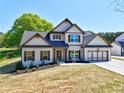 Inviting new construction home featuring a well-maintained lawn and charming architectural details at 3132 Rosebud Rd, Loganville, GA 30052