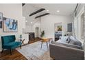 Open-concept living room featuring high ceilings with exposed beams, hardwood floors, and modern furniture at 3566 Orchard Dr, Decatur, GA 30032