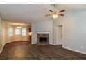 Spacious living room featuring a cozy fireplace, ceiling fan, and modern flooring at 39 Spring Leaf Pl, Dallas, GA 30157