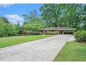 Spacious driveway leading to a brick home with a well-maintained lawn and mature trees at 4807 Kenilworth Dr, Stone Mountain, GA 30083