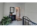 Entryway featuring a staircase, decorative mirror, plant, and black cabinet at 5400 Roswell Rd # N1, Sandy Springs, GA 30342