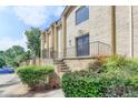 Brick building with well-maintained landscaping, a front door, and a short staircase with wrought iron railings at 5400 Roswell Rd # N1, Sandy Springs, GA 30342
