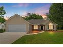 Inviting home featuring a two car garage, stone accents, a manicured lawn, and an inviting front entrance at 102 Pine Bark Dr, Villa Rica, GA 30180