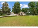 Expansive lawn area surrounds a cozy single-story home with mature trees and charming curb appeal at 102 Pine Bark Dr, Villa Rica, GA 30180