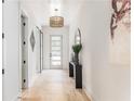 Elegant foyer featuring a hardwood floor, modern light fixture, decorative mirror, and a five-lite glass door at 253 Rockyford Ne Rd, Atlanta, GA 30317