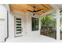 Inviting front porch features a ceiling fan and stylish white painted brick and door at 253 Rockyford Ne Rd, Atlanta, GA 30317