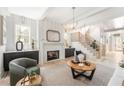 Bright living room with a fireplace, modern lighting, and a staircase at 253 Rockyford Ne Rd, Atlanta, GA 30317