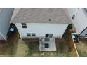 Aerial view of a backyard with a gray concrete patio and modern furniture, enclosed by a fence at 4777 Waxwing St, Hoschton, GA 30548