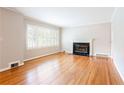 Living room with hardwood floors, fireplace, and large window with plantation shutters at 2227 Leafmore Drive, Decatur, GA 30033