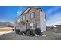 Two-story brick and siding home with mature bushes in the front yard at 8484 Glenview St, Douglasville, GA 30134