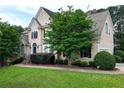 Charming home with a well-maintained lawn, mature trees, and a welcoming facade at 1035 Eagles Brooke Dr, Locust Grove, GA 30248