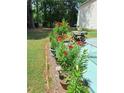 Landscaped backyard with beautiful flowers and a cozy patio area at 3102 Aberdeen Cv, Lithonia, GA 30038