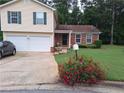 Charming home with a two-car garage, well-maintained lawn, and beautiful landscaping at 3102 Aberdeen Cv, Lithonia, GA 30038
