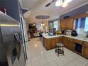 Open kitchen view showcasing stainless steel appliances, tile flooring, and connection to living area at 345 Oak Springs Nw Dr, Lawrenceville, GA 30043