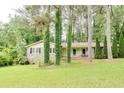 Quaint single-story home featuring a front porch, mature trees, and a well-manicured lawn at 2621 Manor Pl, Ellenwood, GA 30294