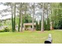 Traditional single-story home with a spacious front lawn, mature trees, and a welcoming entrance at 2621 Manor Pl, Ellenwood, GA 30294