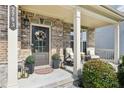 Inviting front porch with comfortable seating, decorative plants, stylish lanterns and a wreath on the front door at 2793 Bloom Cir, Dacula, GA 30019