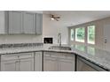 Updated kitchen features granite countertops, stainless steel appliances, and gray cabinets at 1229 Huntington Place Cir, Lithonia, GA 30058