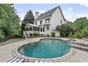 Inviting backyard pool area with stone accents, a covered porch and lush landscaping at 2548 Lakeview East Se Trl, Atlanta, GA 30316