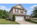 Side view of a charming two-story home with a well-manicured front yard and two-car garage at 345 Lara Ln, Mcdonough, GA 30253