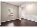 Bright living room featuring hardwood floors, elegant wainscoting, and large windows at 345 Lara Ln, Mcdonough, GA 30253