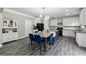 Beautiful kitchen with an island, stainless steel appliances, gray wood floors, and sleek white cabinetry at 4850 Wilshire Xing, Cumming, GA 30040
