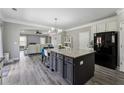 Stylish kitchen with granite countertops, an island with bar seating, and an open layout to the living area at 4850 Wilshire Xing, Cumming, GA 30040