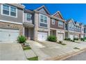 A row of charming townhomes each featuring attached garages and driveways with well-maintained landscaping at 5009 Longview Walk, Decatur, GA 30035
