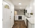 Bright kitchen featuring white cabinets, quartz countertops, stainless steel appliances, and dark wood floors at 1019 Crestwood Ln, Stone Mountain, GA 30087