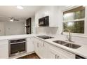 Well-lit kitchen with stainless steel appliances, bright white cabinets, quartz countertops, and a view of the backyard at 1019 Crestwood Ln, Stone Mountain, GA 30087