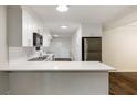 Modern kitchen features white cabinetry, stainless steel appliances, subway tile backsplash, and wood floors at 1019 Crestwood Ln, Stone Mountain, GA 30087