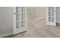 Bright hallway showcasing light gray flooring and white french doors offering a modern and stylish entrance at 1651 Tide Mill Rd, Cumming, GA 30040