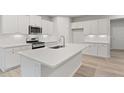 Beautiful kitchen featuring a large center island, stainless steel appliances, and white cabinetry at 1651 Tide Mill Rd, Cumming, GA 30040
