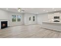 Open-concept living room with fireplace, light wood flooring, and natural light creates a warm and inviting atmosphere at 1651 Tide Mill Rd, Cumming, GA 30040