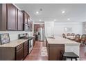 Modern kitchen with stainless steel appliances, granite countertops, and dark wood cabinets at 221 Irwell Path, Lawrenceville, GA 30044