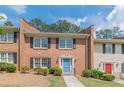 Brick townhome featuring a blue front door, manicured lawn, and black shutters at 4101 Dunwoody Club Dr # 49, Atlanta, GA 30350