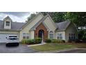 Charming home with lush landscaping, brick accents, and attached garage at 1231 Creek Forest Ln, Austell, GA 30106