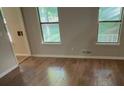 Cozy bedroom with hardwood floors, neutral walls, and two windows providing ample light at 145 Huntcliff Ct, Fayetteville, GA 30214
