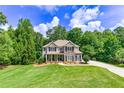 Lovely two-story home with classic design, surrounded by a well-manicured lawn and mature trees at 255 Ashmere Ct, Tyrone, GA 30290