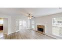 Bright living room with hardwood floors, fireplace, and French doors leading to another room filled with windows at 4884 Antelope Cv, Atlanta, GA 30349