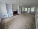 Spacious living room with fireplace, built-in bookshelves, and natural light at 639 Royal Abbey Dr, Stone Mountain, GA 30088