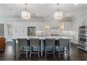 Bright, modern kitchen with a large center island, pendant lighting, and stainless steel appliances at 6805 Bucks Rd, Cumming, GA 30040