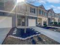 Street view of modern townhomes showcasing gray exterior, private garages, and small front yards at 7119 Gladstone Cir, Lithonia, GA 30038