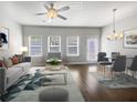 A bright living room with a ceiling fan, hardwood floors, and natural light from the windows at 7119 Gladstone Cir, Lithonia, GA 30038