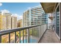 The condo balcony offers a view of the community swimming pool and other buildings, creating a vibrant urban landscape at 950 W Peachtree Nw St # 1214, Atlanta, GA 30309