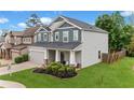Charming two-story home with lush green lawn and manicured landscaping at 100 Grove View Rd, Woodstock, GA 30189